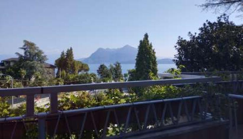 Vista serena su lago e montagne, natura rigogliosa.